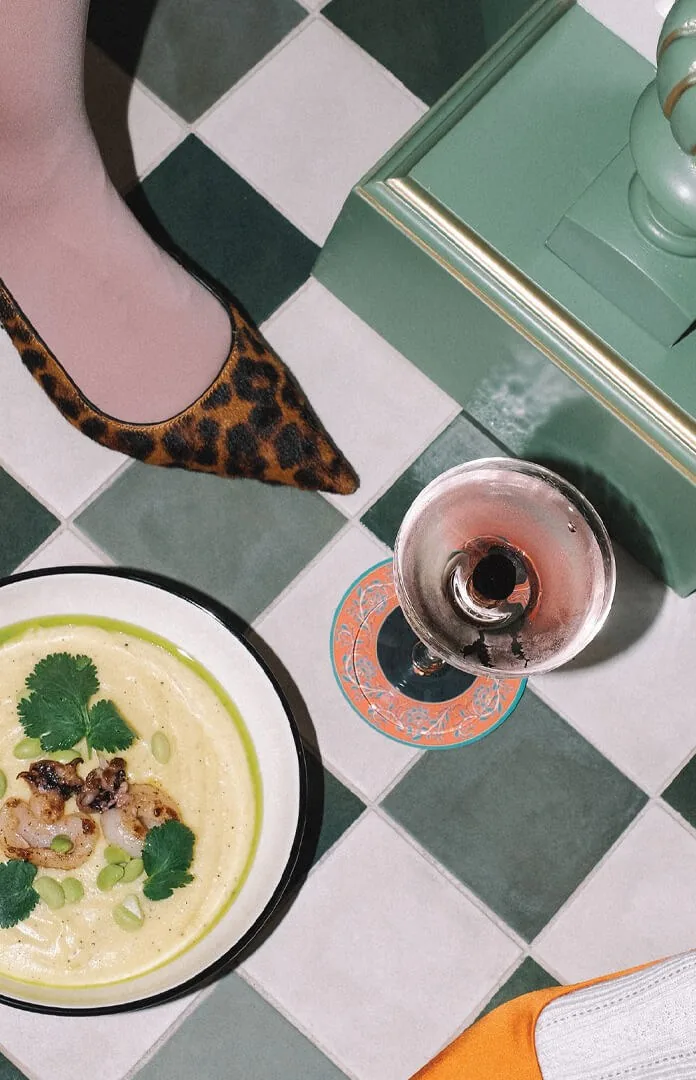 A plate and a glass of wine on a green checkerboard table