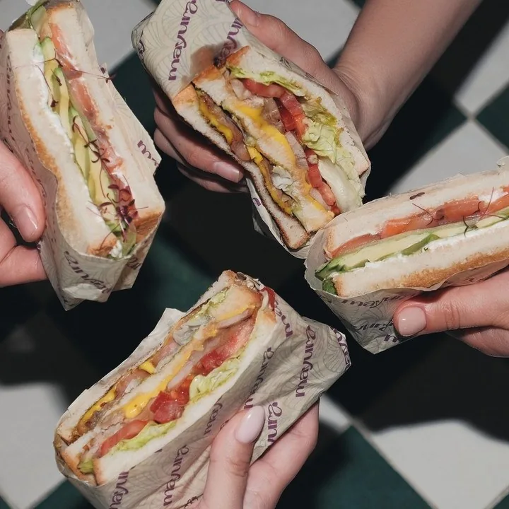Club sandwich halves passed around the table